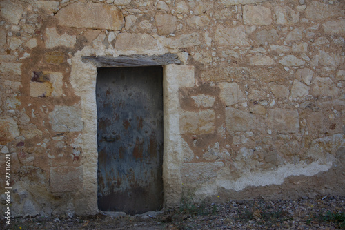 Old door integrated on stone wall. Selective focus. Copy space.