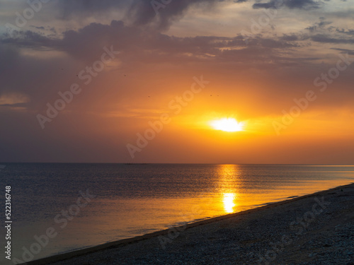 Tropical sea sunset. Beautiful view of the sunset in the sea, yellow and orange sky and waves in the seascape above the horizon in the ocean © Alekskan12