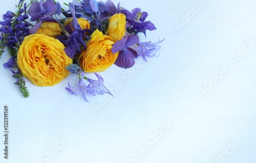 Fototapeta Naklejka Na Ścianę i Meble -  A festive bouquet with yellow ranunculi on a white background. A bright floral arrangement. Background for a greeting card.