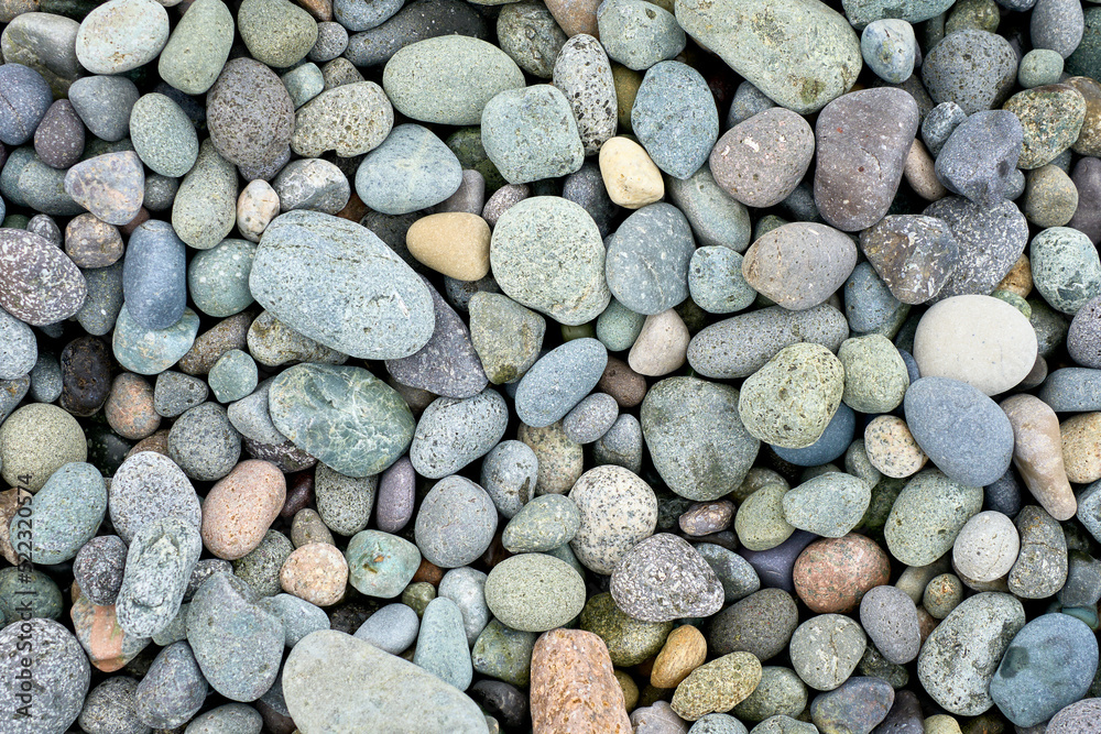 Abstract background texture of random sizes of stones and colored smooth pebbles on the seashore Abstract background texture of random sizes of stones and colored smooth pebbles on the seashore