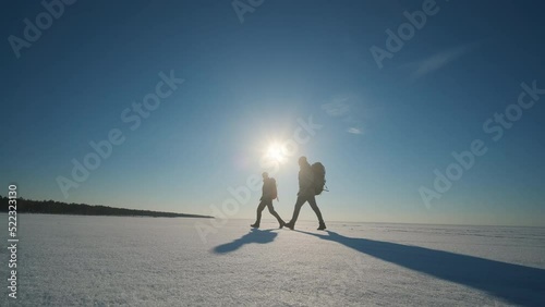 The two travelers walking through the snowy field. slow motion photo