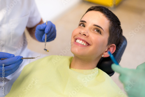 Young woman checking her teeth at the dentist clinic
