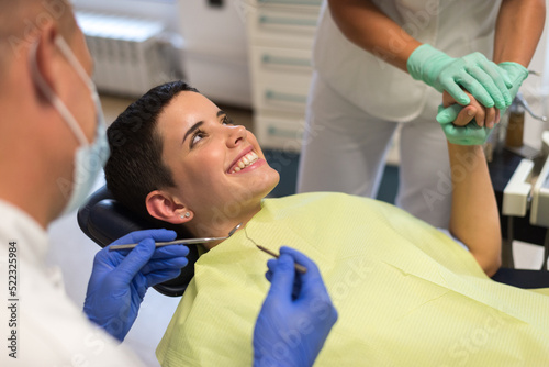 Young woman checking her teeth at the dentist clinic