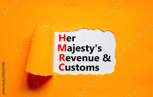 HMRC her majestys revenue and customs symbol. Concept words HMRC her majestys revenue and customs on white paper on beautiful orange background. Business HMRC revenue and customs concept. Copy space. photo
