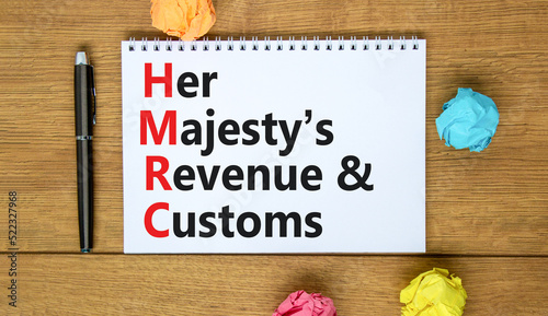 HMRC her majestys revenue and customs symbol. Concept words HMRC her majestys revenue and customs on white note on beautiful wooden background. Business HMRC revenue and customs concept. Copy space. photo