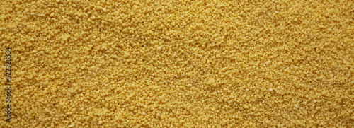 Fotografie Raw organic couscous background, top view.
