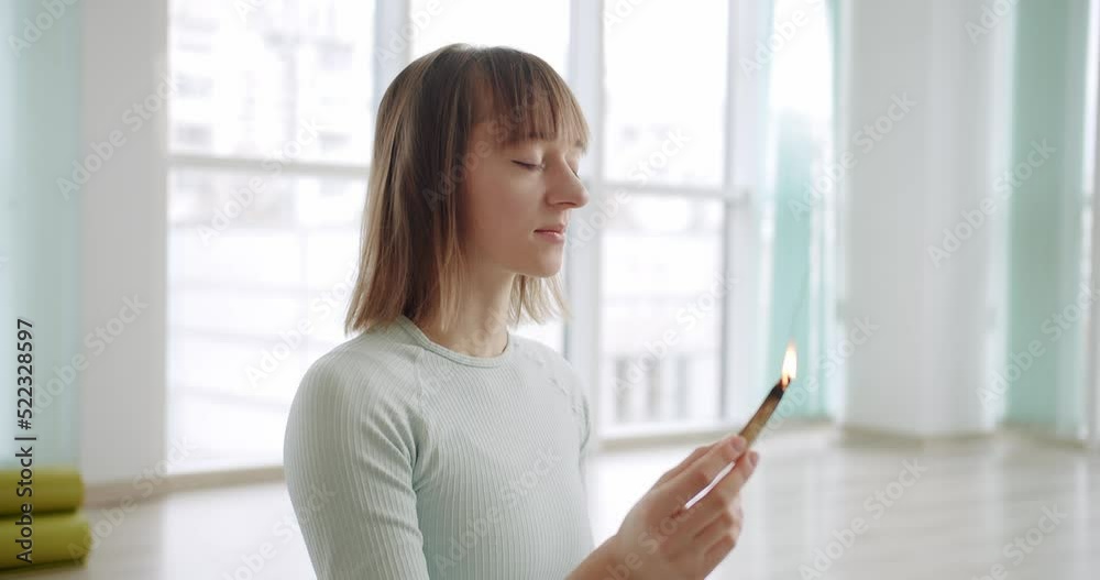 Woman meditating with Palo Santo, holy wood, relaxation zen practice in studio, herbal healing, yoga or aura cleaning. Bursera Graveolens. Essential incense for esoteric rituals. Woman meditating with Palo Santo, holy wood, relaxation zen practice in studio, herbal healing, yoga or aura cleaning. Bursera Graveolens. Essential incense for esoteric rituals.