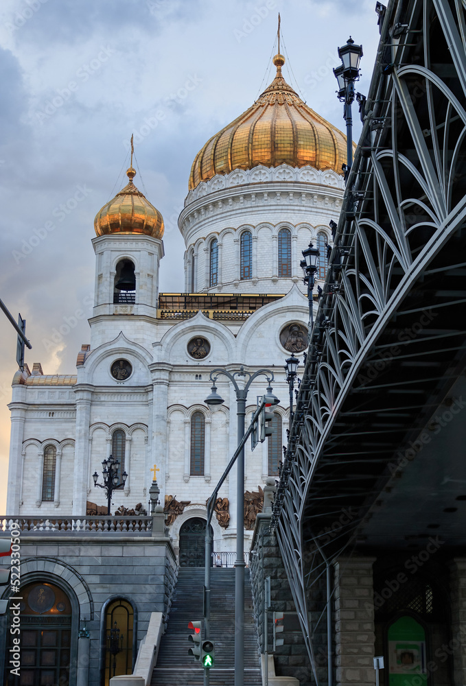 Cathedral of Christ the Savior, stairs to the temple and a metal openwork bridge with lanterns. Center of Moscow, summer evening.