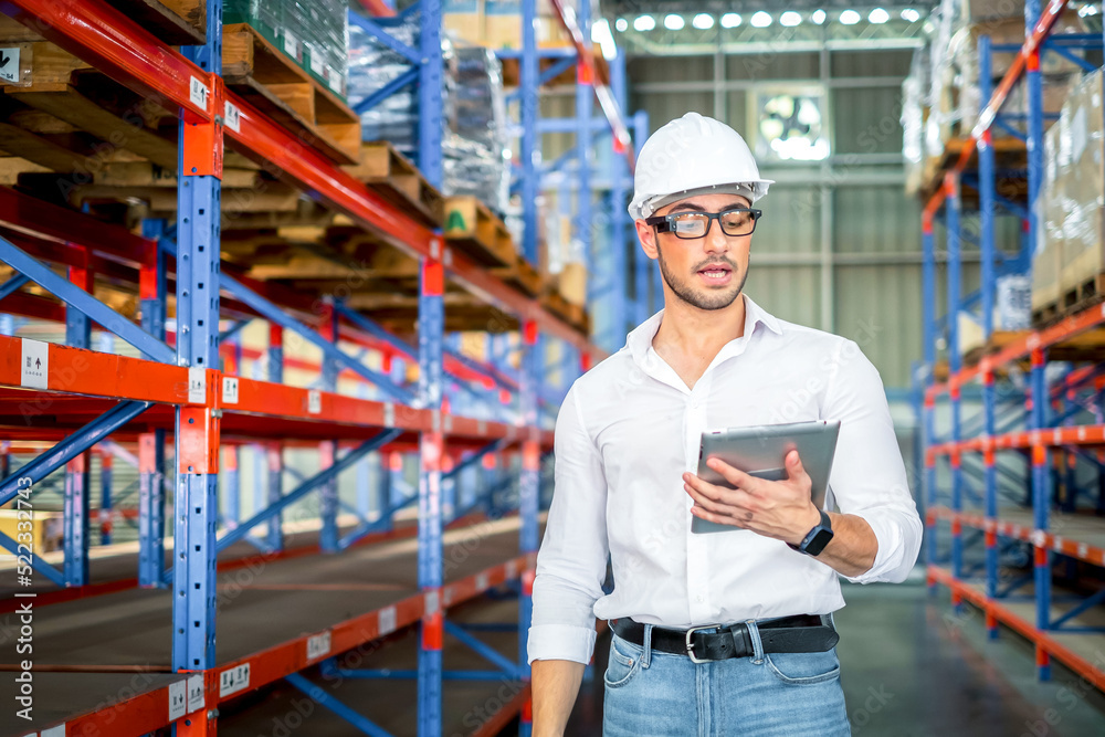 Fototapeta premium Young worker working in an industrial place of work. logistics service, warehouse management and inventory concept.