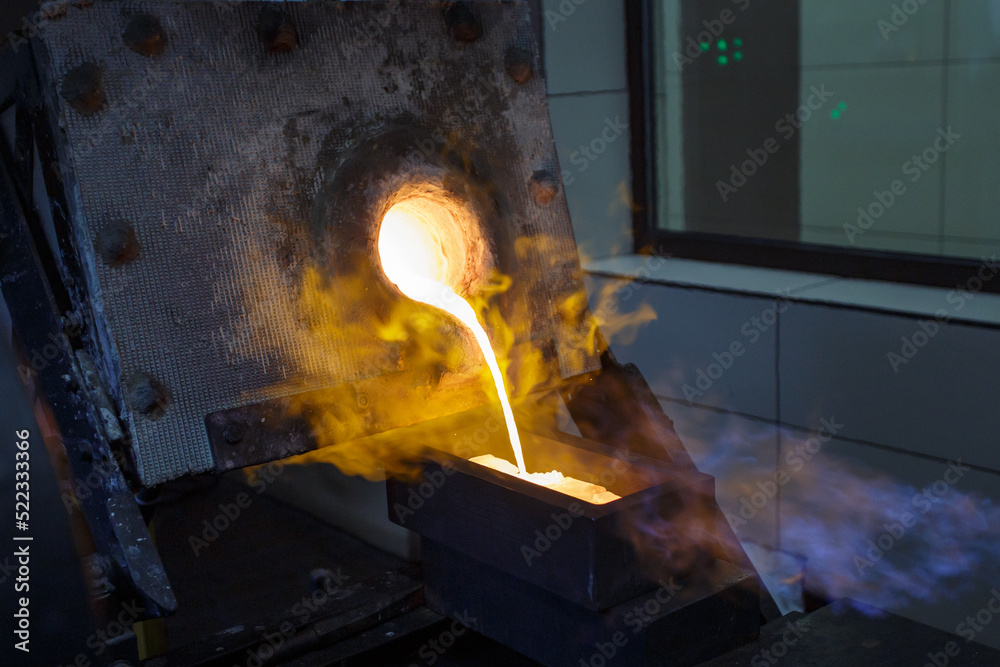 Fotografie Pouring hot liquid gold into molds.