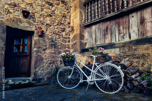 Bicycle with basket in fromt of old wall with flowers