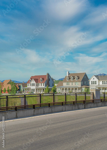 Vertical Whispy white clouds Paved road bridge with railings and barriers on the sidewalk at