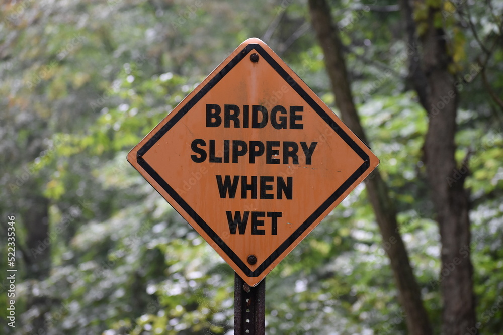 Bridge slippery when wet sign on a road