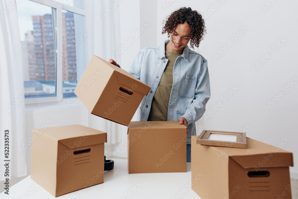 portrait of a man cardboard boxes in the room unpacking Lifestyle portrait of a man cardboard boxes in the room unpacking Lifestyle