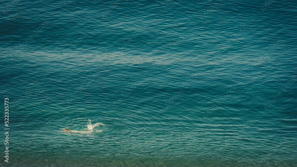 Aerial view of swimming woman in blue mediterranean sea, Spain Aerial view of swimming woman in blue mediterranean sea, Spain