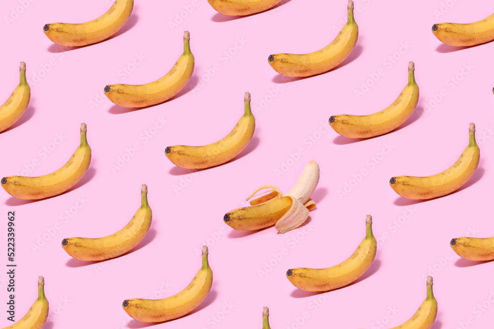 Yellow banana pattern with one peeled banana on a pink background.
