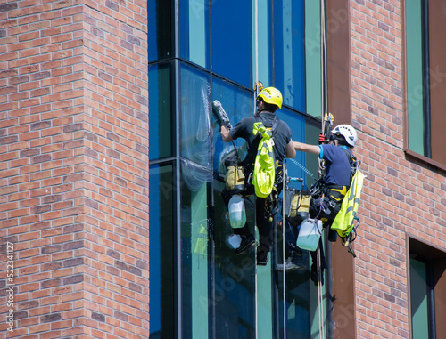 Fotografie two abseiling window cleaners on office building