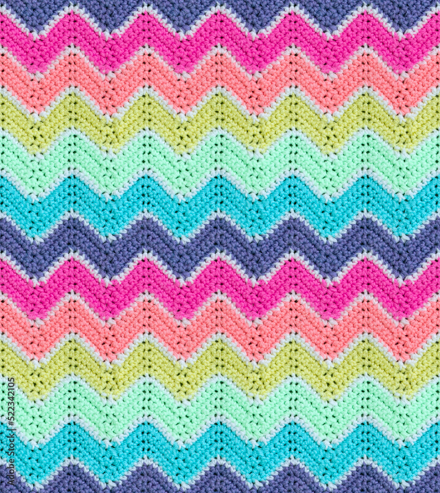 Seamless knitted pattern in the form of zigzags is crocheted with multi-colored threads. Acrylic baby yarn. Delicate light colors.