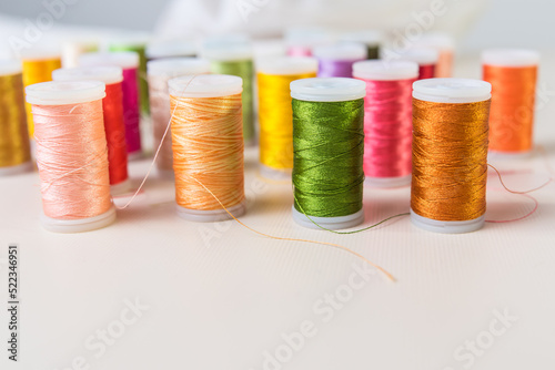 green and orange, close-ups of colored threads, dressmaker, atelier, seamstress, sewing clothes, embroidering fabric, needle and thread, selective focus