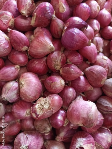 Red onions on market stall. Closeup of fresh raw onion food background. Organic onions top view. Food background. Selective focus. Red onions in plenty.
