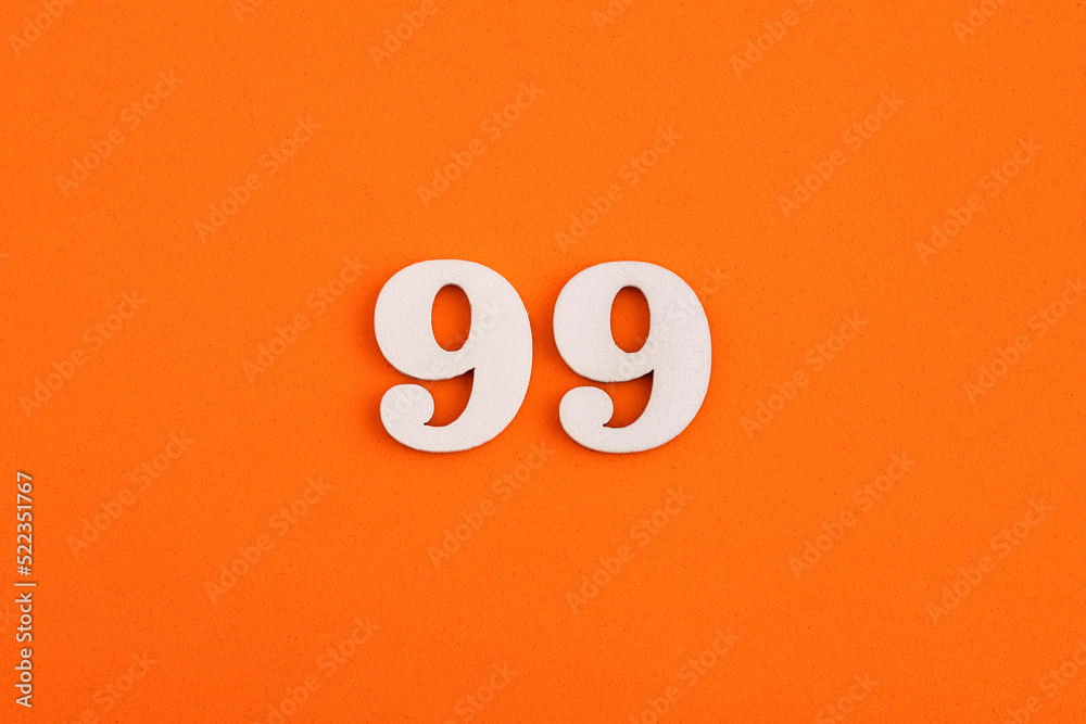 White wooden number 99 on eva rubber orange background White wooden number 99 on eva rubber orange background