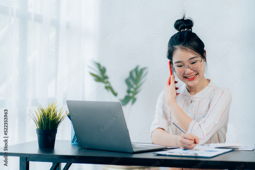 Young asian businesswoman beautiful charming smiling and talking on the mobile phone in the office Young asian businesswoman beautiful charming smiling and talking on the mobile phone in the office