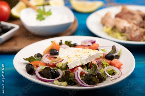 A rustic greek salad served on a white plate