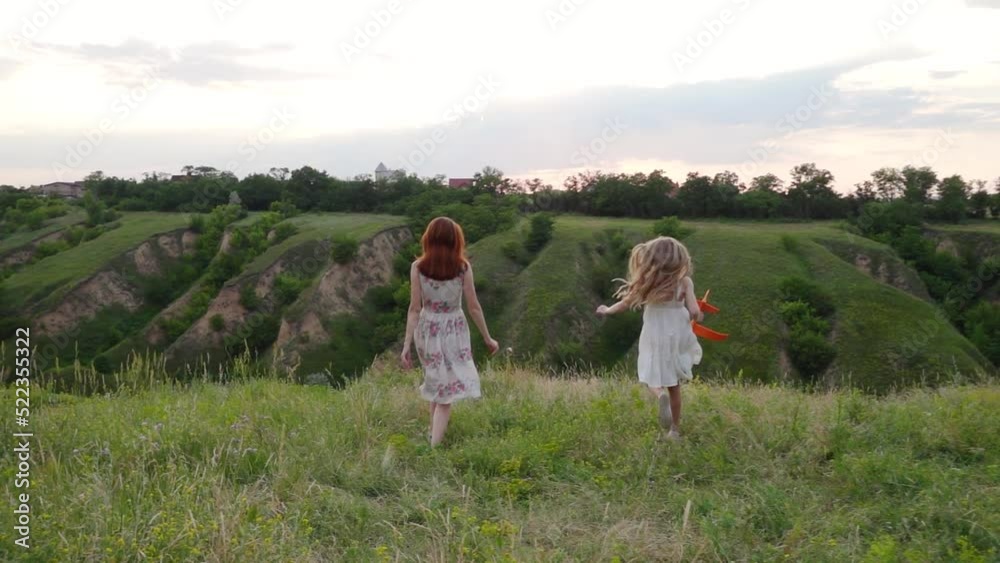 mother and daughter playing with the toy airplane at the sunset meadow
mother and daughter playing with the toy airplane at the sunset meadow
