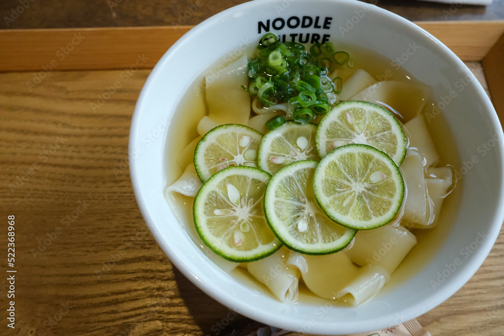 Close up tanuki udon, japanese noodles with fresh lime slice and cold soup, summer dish. Close up tanuki udon, japanese noodles with fresh lime slice and cold soup, summer dish.