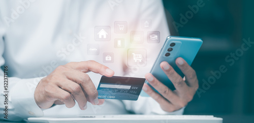 Young businessman using credit card to make financial transactions via smartphone, payment concept with wireless communication technology, focus on consumer safety and cashlessness. photo