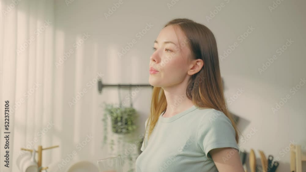 Beautiful Caucasian woman drinking a glass of water in kitchen at home Beautiful Caucasian woman drinking a glass of water in kitchen at home
