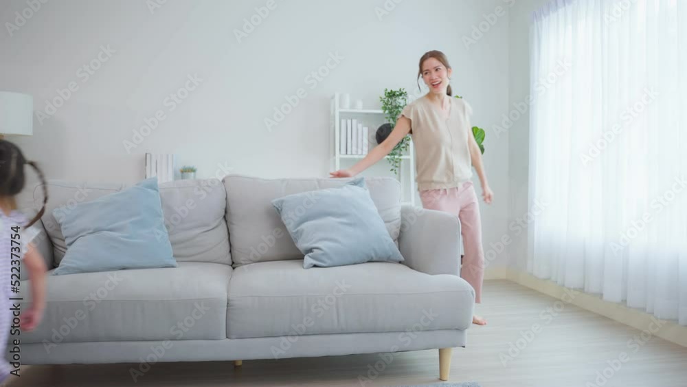Asian attractive parents play with daughters in living room at home. Asian attractive parents play with daughters in living room at home.