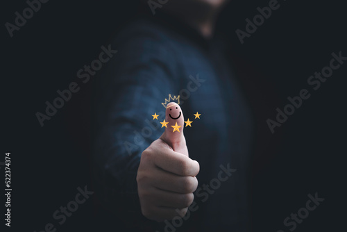 Businessman thumb rise up with five stars and smile face for the best customer evaluation rating after use product and service concept.