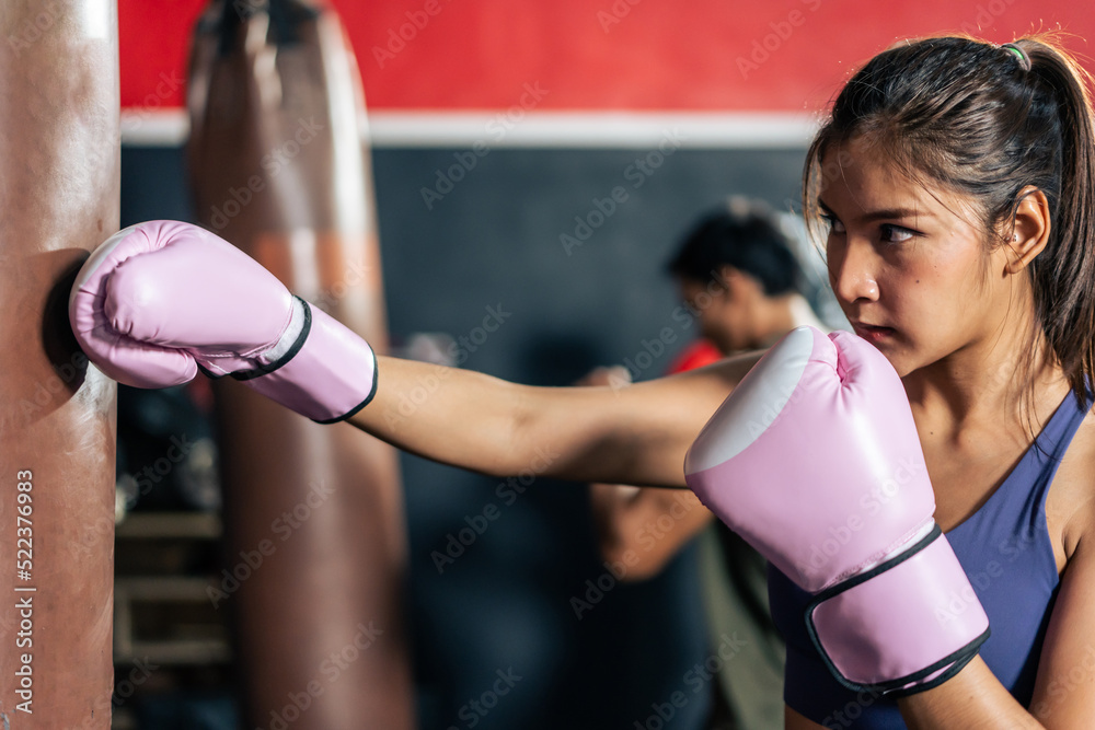 Asian active female sportswoman wearing sport clothes and boxing glove