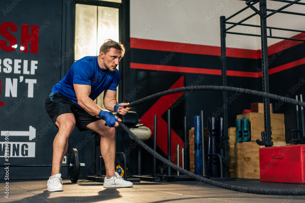 Obraz premium Caucasian active handsome sportsman working out in fitness gym club. 
