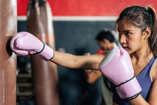 Asian active female sportswoman wearing sport clothes and boxing glove