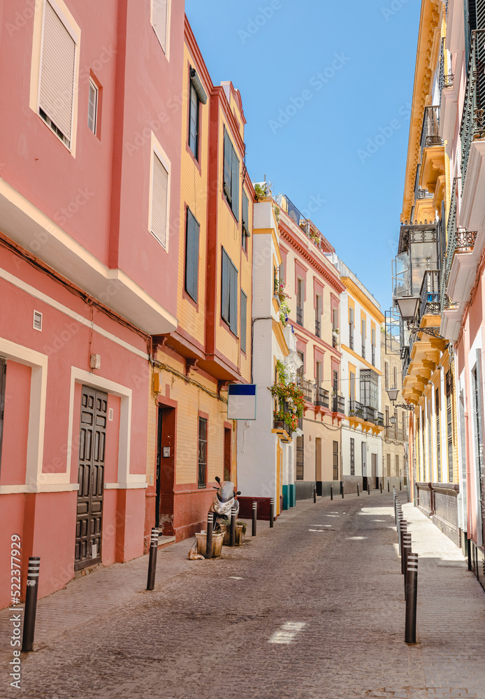 Obraz premium A colorful European street scene with nobody. Spanish architecture in the city of Seville.