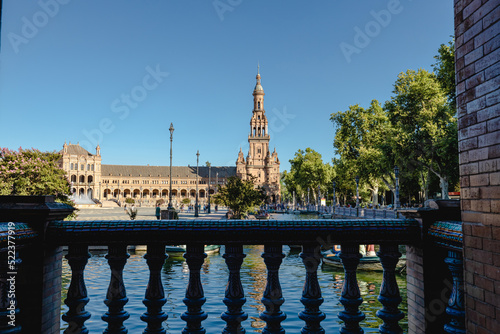 The Plaza de España in Seville, Spain. This beautiful scenic shot of the tower and water is peaceful and elegant landscape for traveling Europe.