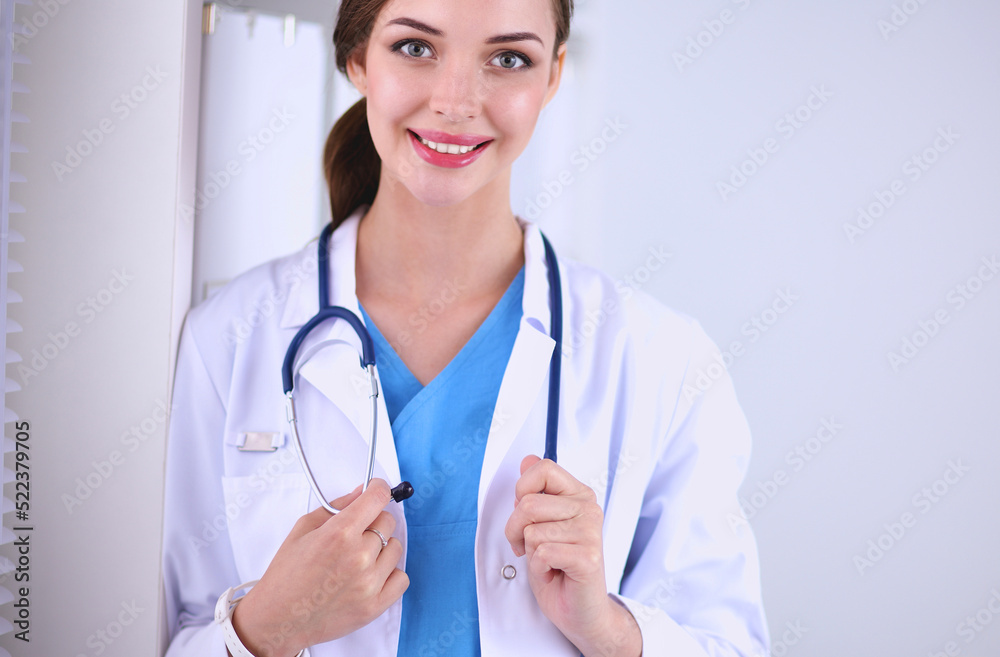 Woman doctor is standing near window with crossed arms,isolated Woman doctor is standing near window with crossed arms,isolated