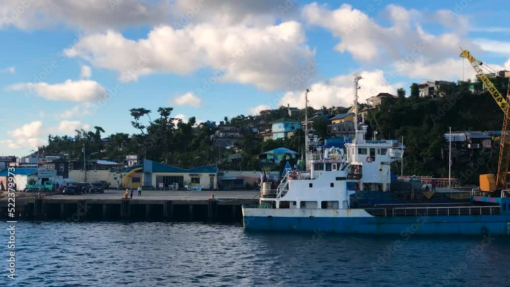 Ship Docked In The Seaport Of Dinagat Island With People Standing In The Background. - zoom in Ship Docked In The Seaport Of Dinagat Island With People Standing In The Background. - zoom in