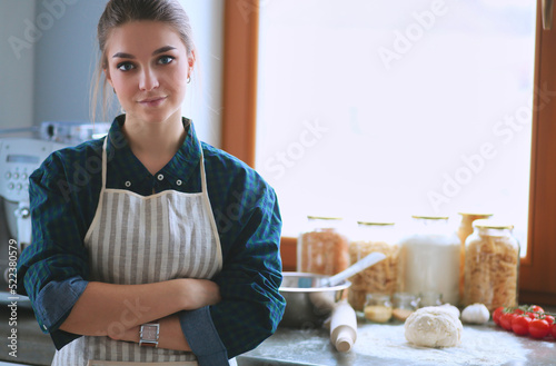 Smiling woman online shopping using tablet and credit card in kitchen