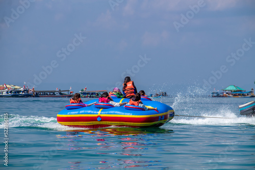 People riding banana boats while traveling to the beach