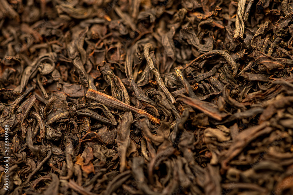 Large-leaved black tea in bulk on the table. Close-up of the surface texture Large-leaved black tea in bulk on the table. Close-up of the surface texture