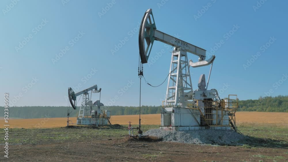 Pumping rigs extracting oil from an oil well in vast oil field. Oil Industry Equipment. Pumping rigs extracting oil from an oil well in vast oil field. Oil Industry Equipment.