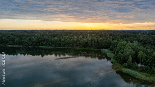 Aerial view  shot by a drone of a sunset at coast of the lake. Nature landscape. Nature in northern Europe. reflection  blue sky and yellow sunlight. landscape during sunset. High quality photo