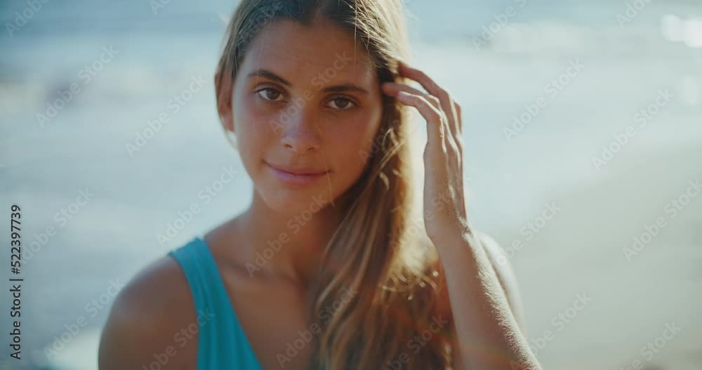 Portrait of beautiful attractive young woman at the beach, looking into the camera, summer lifestyle