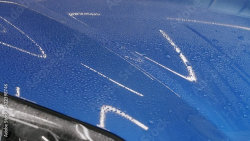 Close up footage testing hydrophobicity effect on car mask. Water droplets falling from the hood. photo