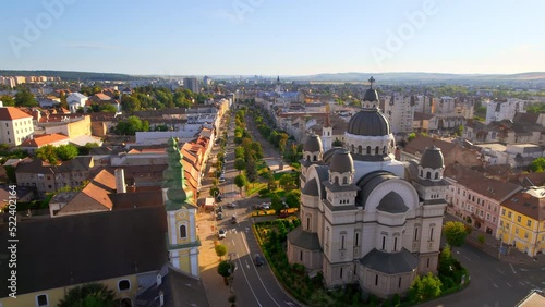 Aerial drone view of Ascension of the Lord Cathedral in the centre of Targu Mures, Romania. Old buildings, greenery, roads with cars