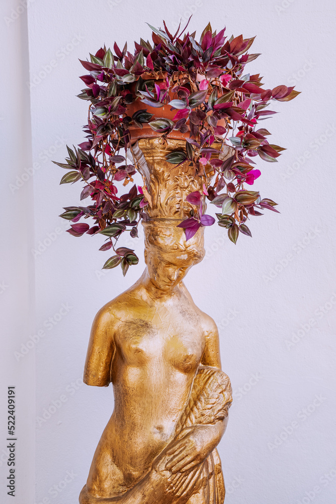 A flower pot with a plant in the form of a statue of the goddess of love Aphrodite in Greece