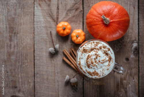 Autumn spicy pumpkin drink, pumpkin latte on wooden background top view